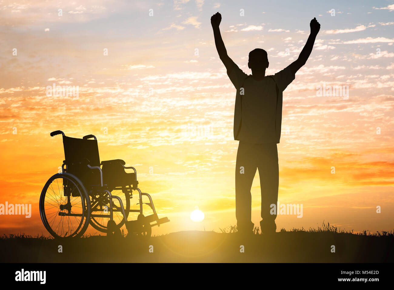 Silhouette de Miracle homme handicapé à marcher au coucher du soleil Banque D'Images