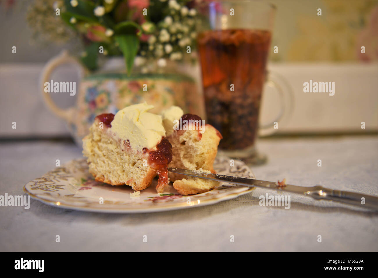 Le thé de l'après-midi avec la vaisselle floral vintage crème et confiture scone Banque D'Images