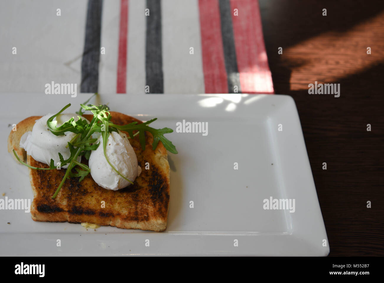 Petit-déjeuner délicieux servi avec des œufs pochés sur toast Banque D'Images