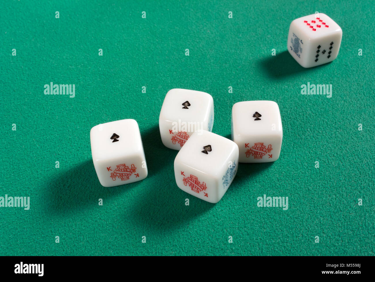 Dés de poker sur un tableau vert avec un quatre d'une sorte d'as Banque D'Images