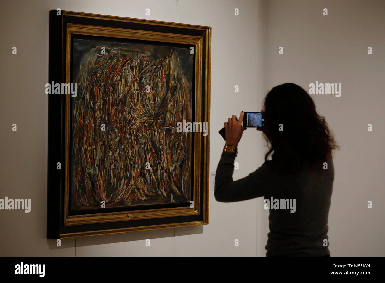 Londres, Royaume-Uni. 20 Février, 2018. Un employé utilise un téléphone portable à côté d'une peinture à l'huile 'L'incindie I (I) le feu" par l'artiste Maria Helena Vieira da Silva à la maison Christie's à Londres Le mardi 20 février 2018. L'œuvre, d'une valeur estimative de 1,5 million de livres sterling, seront vendus à l'après-guerre et l'Art Contemporain vente du soir le 6 mars. Credit : Luke MacGregor/Alamy Live News Banque D'Images