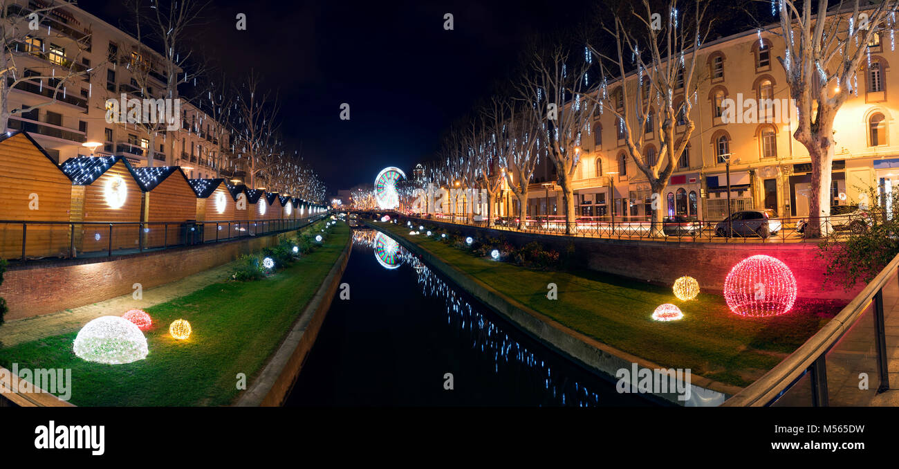 Vue de nuit de la ville de Perpignan (France) pendant la période de Noël. Belles lumières et d'un la touch a une juste avec une grande roue à l'arrière. Banque D'Images