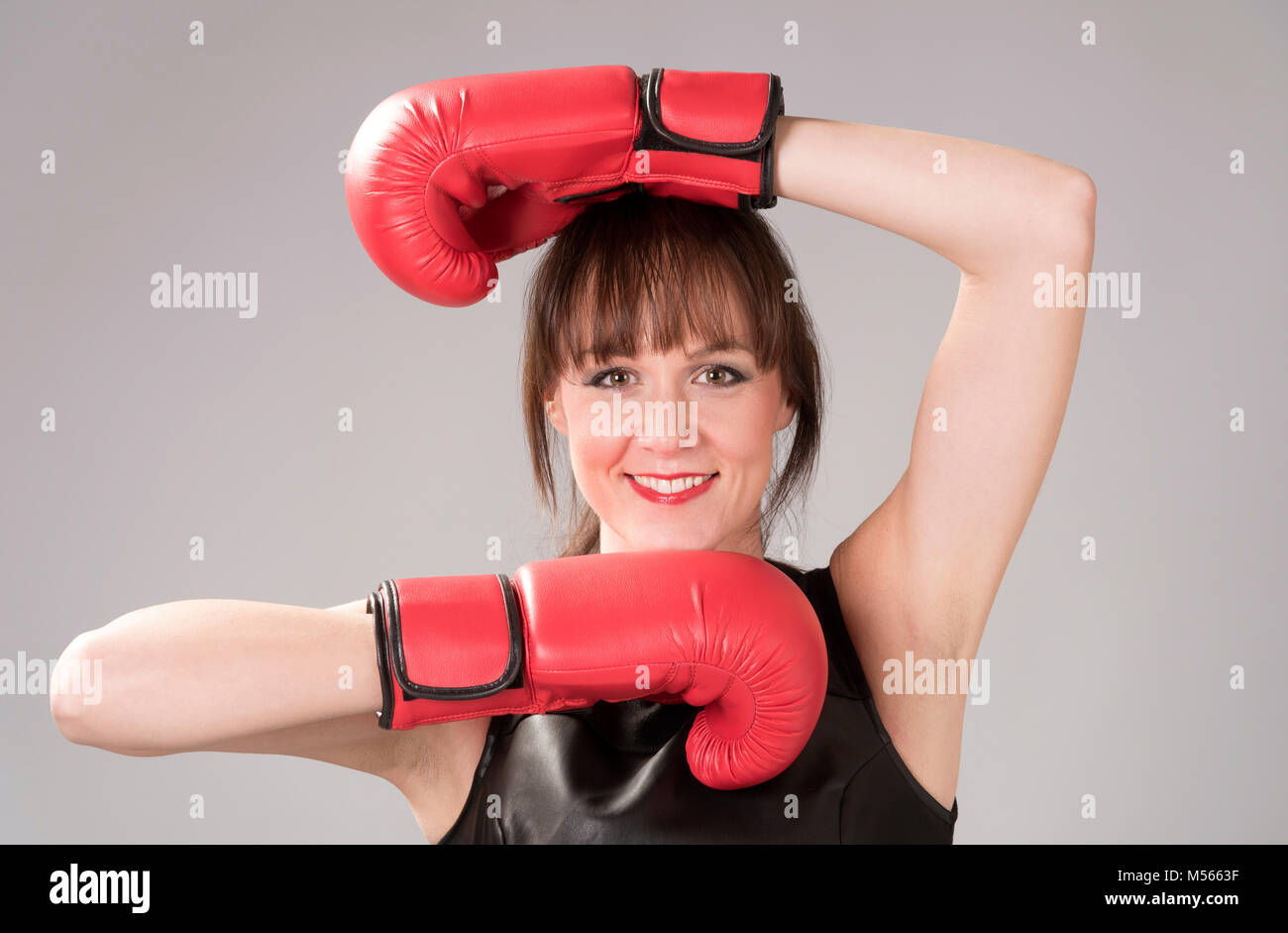 Femme portant un haut de cuir noir et rouge gants de boxe Banque D'Images