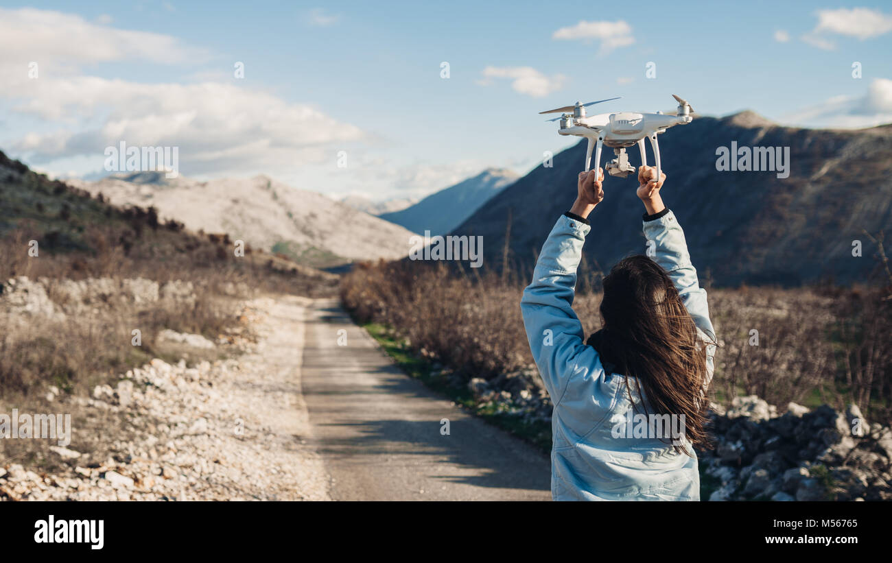Jeune femme vidéaste attraper à voler avec camera.Contrôler le débarquement de drone.cinéaste femelle dans la nature en utilisant quad copter aéronef à ca Banque D'Images