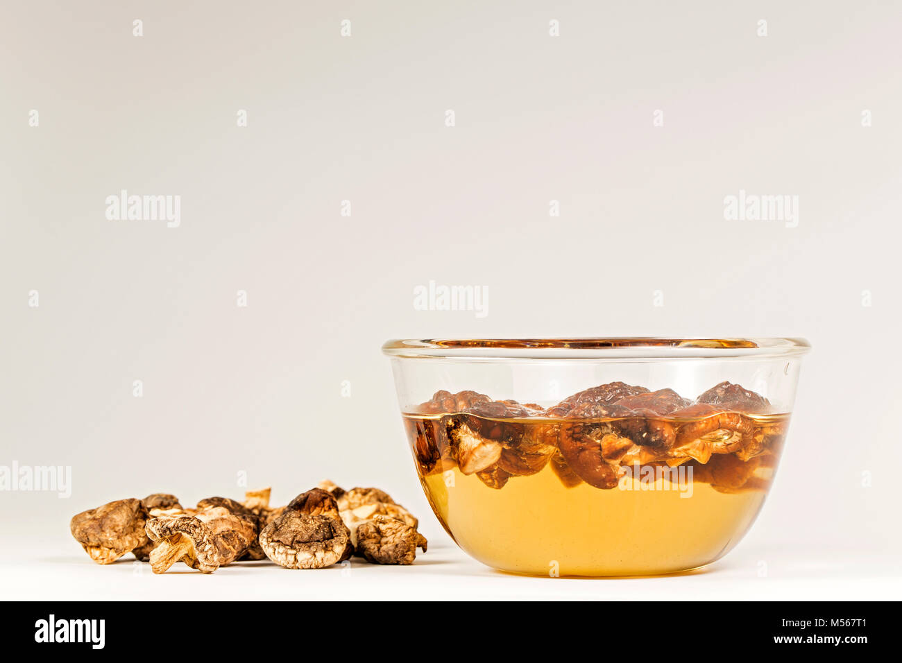 Shiitake sec et humide entre sur le fond blanc. Banque D'Images