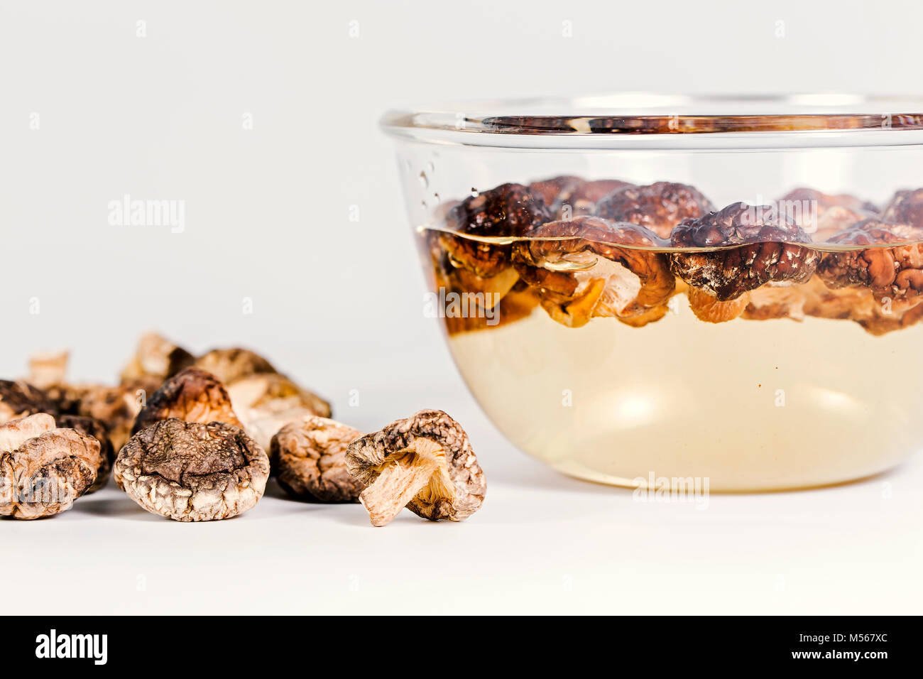 Shiitake sec et humide entre sur le fond blanc. Banque D'Images