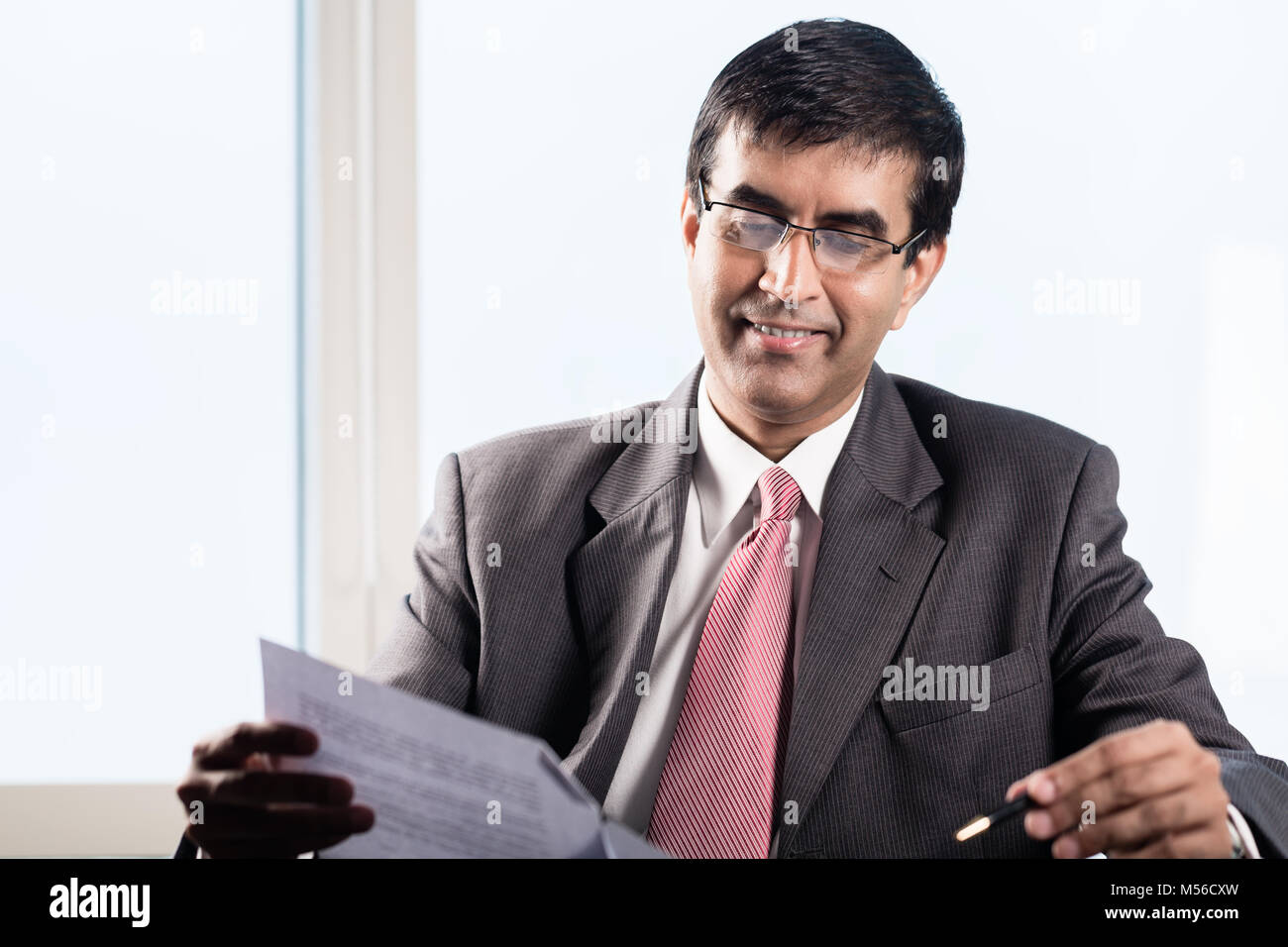 La haute direction indienne dans son bureau gratte-ciel, la lecture des contrats commerciaux Banque D'Images