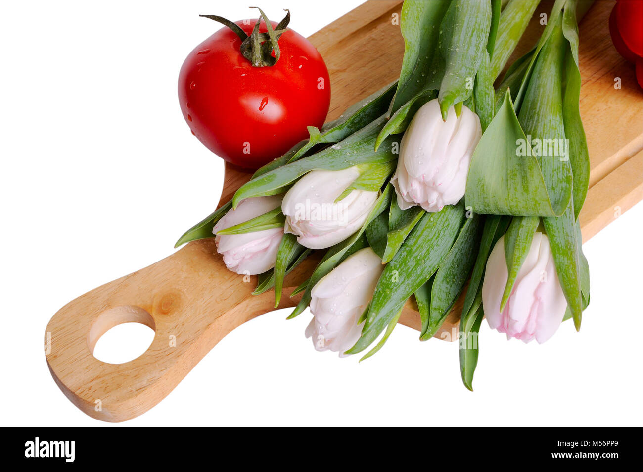 Nature morte avec tulipes et tomate, gros plan sur fond blanc Banque D'Images