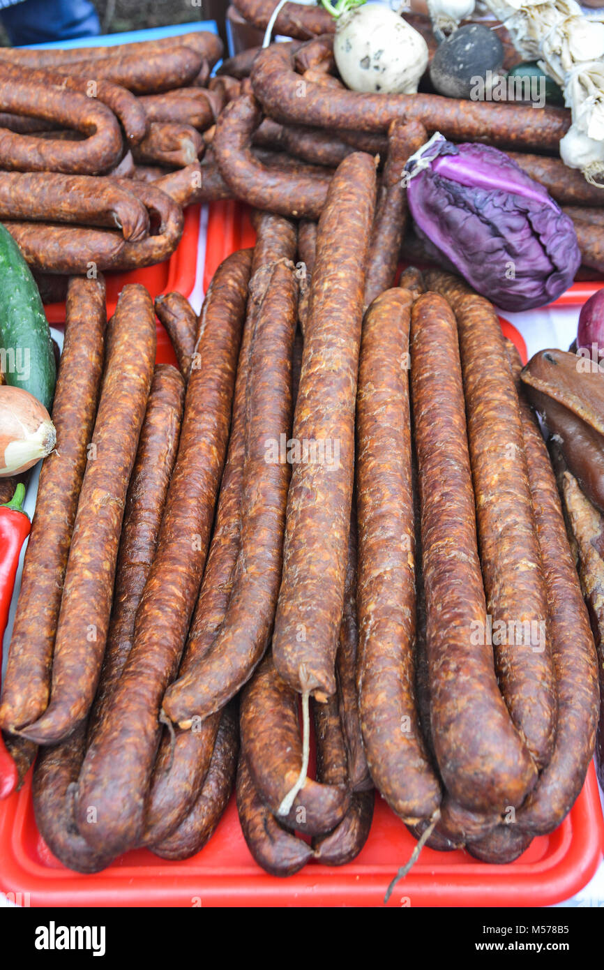 Des saucisses de porc fumé et séché debout sur la table pour la vente. Banque D'Images Des saucisses de porc fumé et séché debout sur la table pour la vente. Banque D'Images