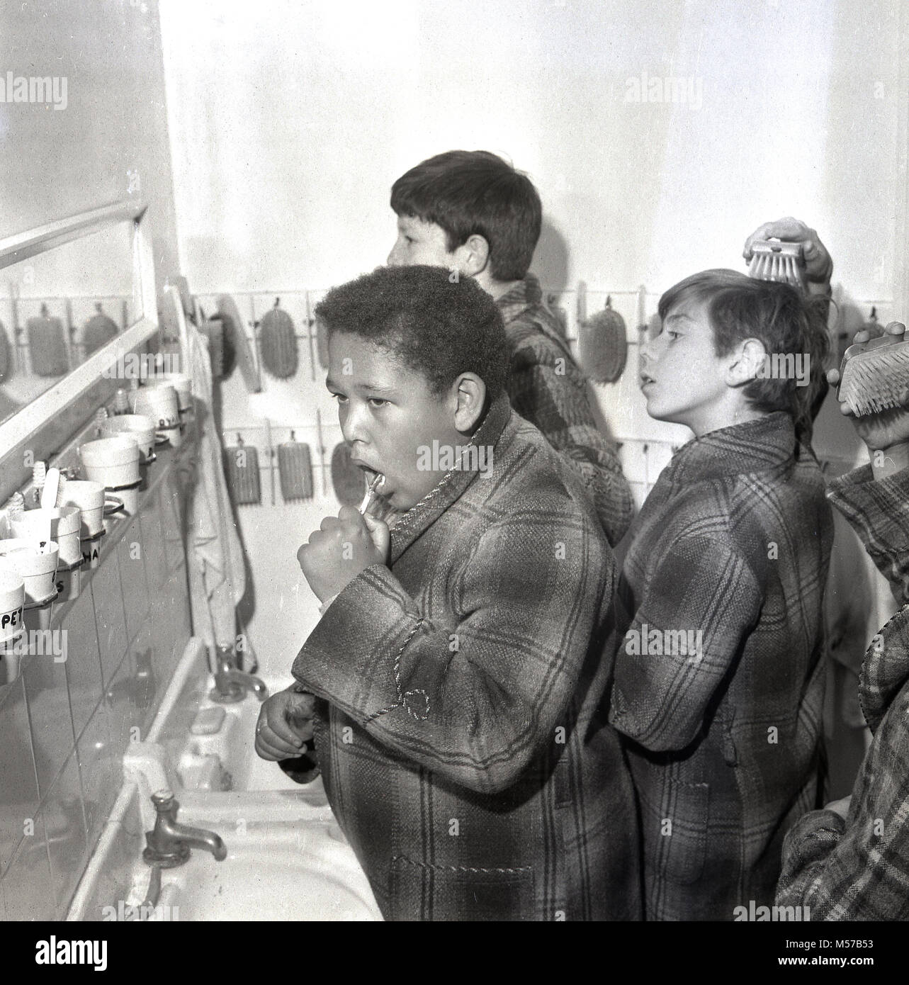 1968, historique, dans le sud de Londres, les jeunes garçons dans un internat de l'état dans leurs robes de nettoyer leurs dents avant de se coucher. Banque D'Images