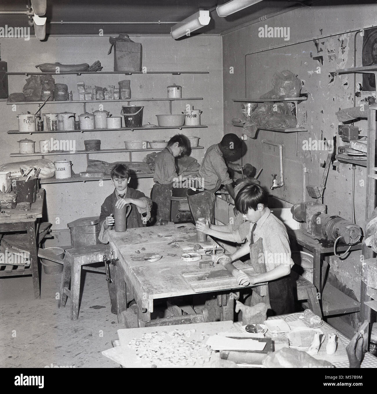 1968, South London,UK, des garçons dans un internat de l'état obtenir malpropre avec de la pâte à modeler de faire une classe de poterie. Banque D'Images