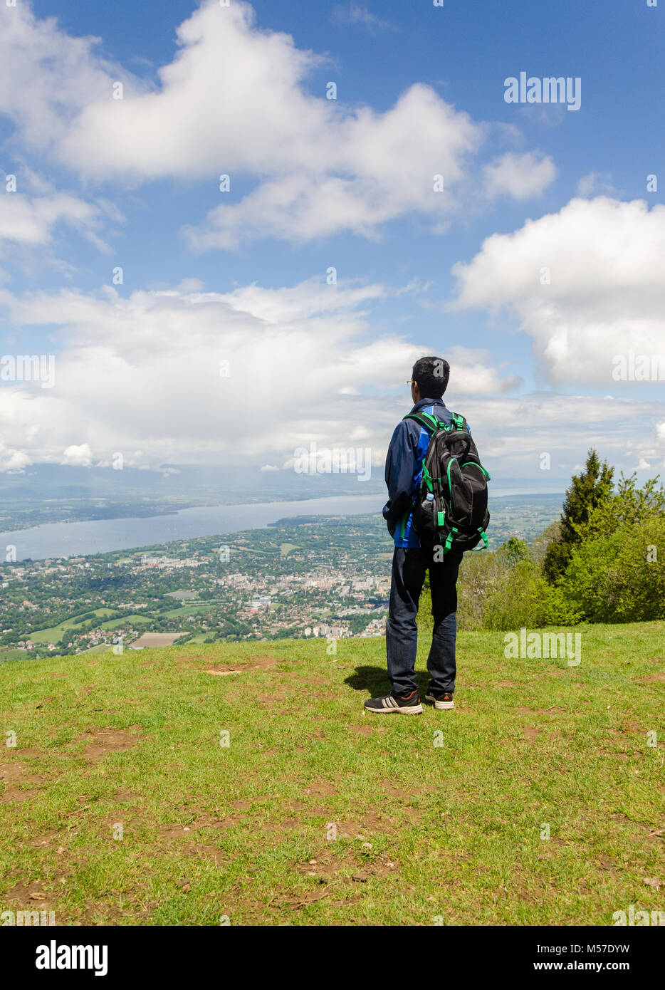 Vue arrière de jeunes adultes en garçon avec sac à dos, sur la ville de Genève, du Mont Salève, France. Banque D'Images