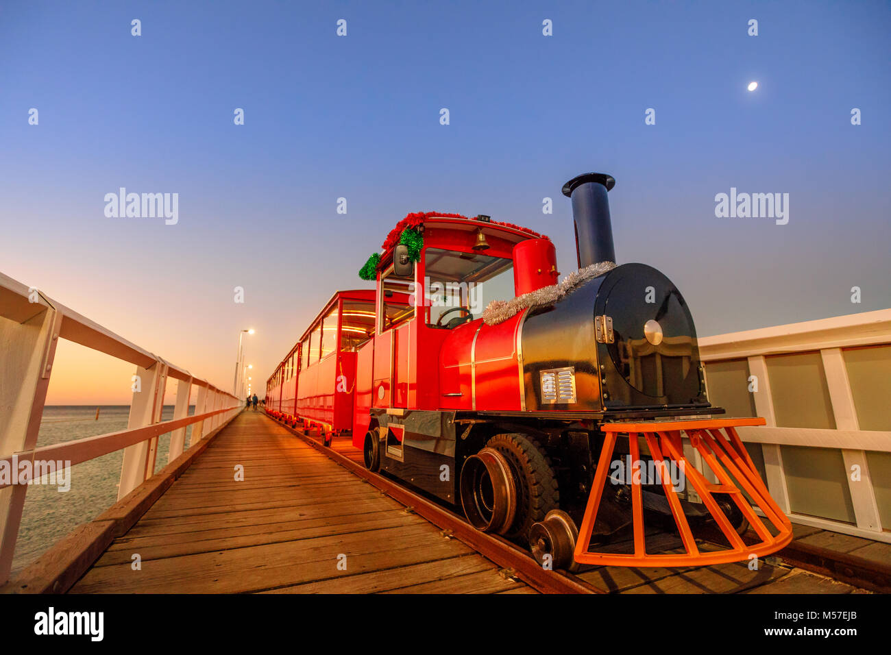 Vue en perspective du train de Busselton Jetty à Busselton, Australie de l'Ouest à l'heure bleue. Paysage panoramique du célèbre monument au coucher du soleil. Busselton Jetty est la plus longue jetée en bois dans le monde. Banque D'Images