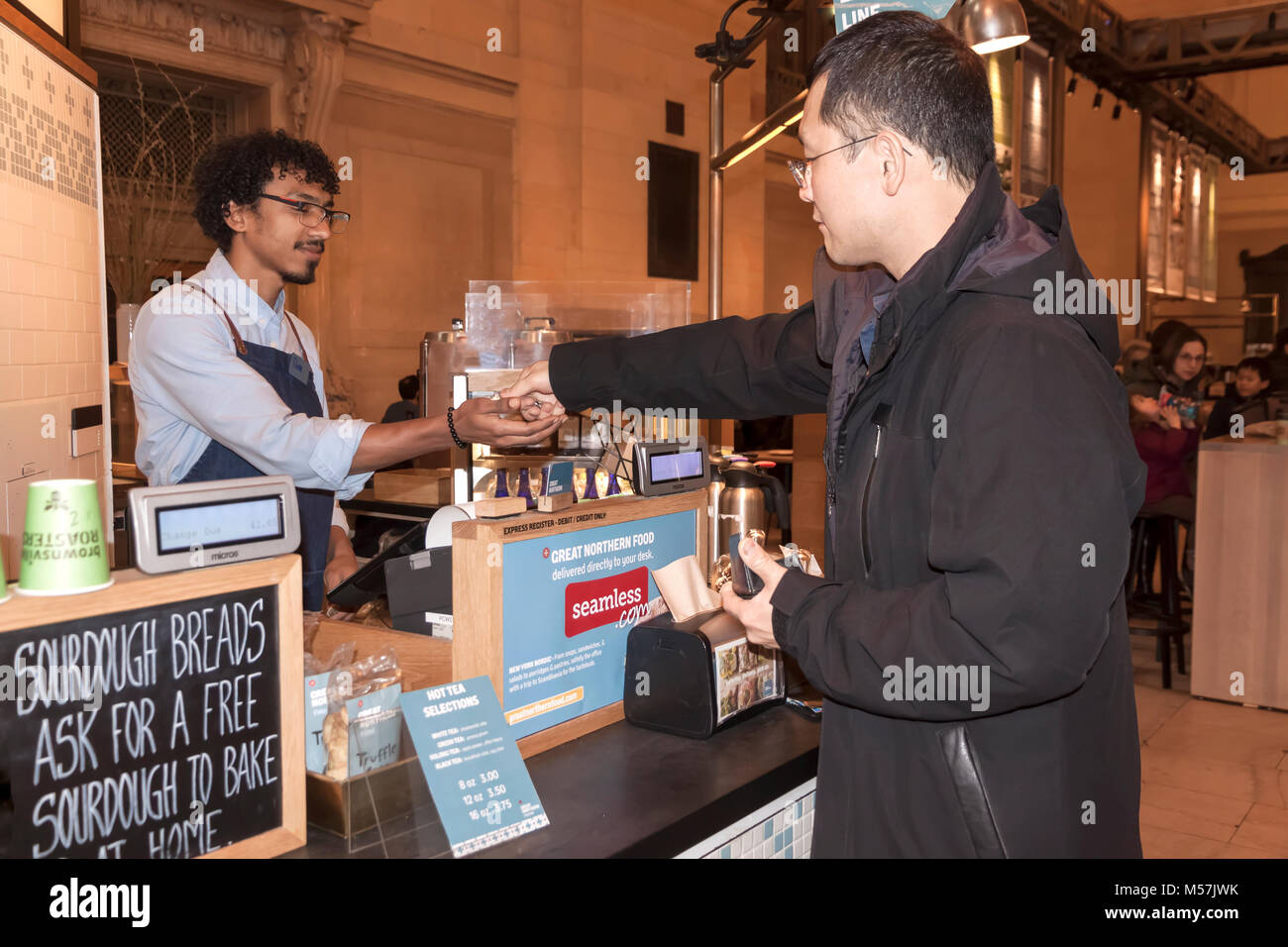 La clientèle masculine avec des pièces de monnaie pour payer les aliments/boissons à Grand Central Station, Great Northern Food Hall de restauration. Banque D'Images