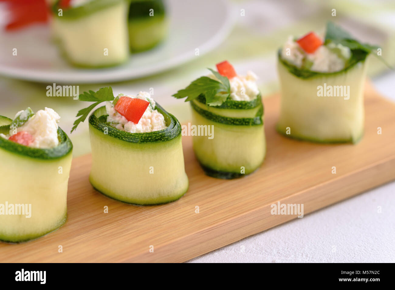 Rouleaux de courgettes farcies au fromage et ciboulette et paprika rouge. Banque D'Images