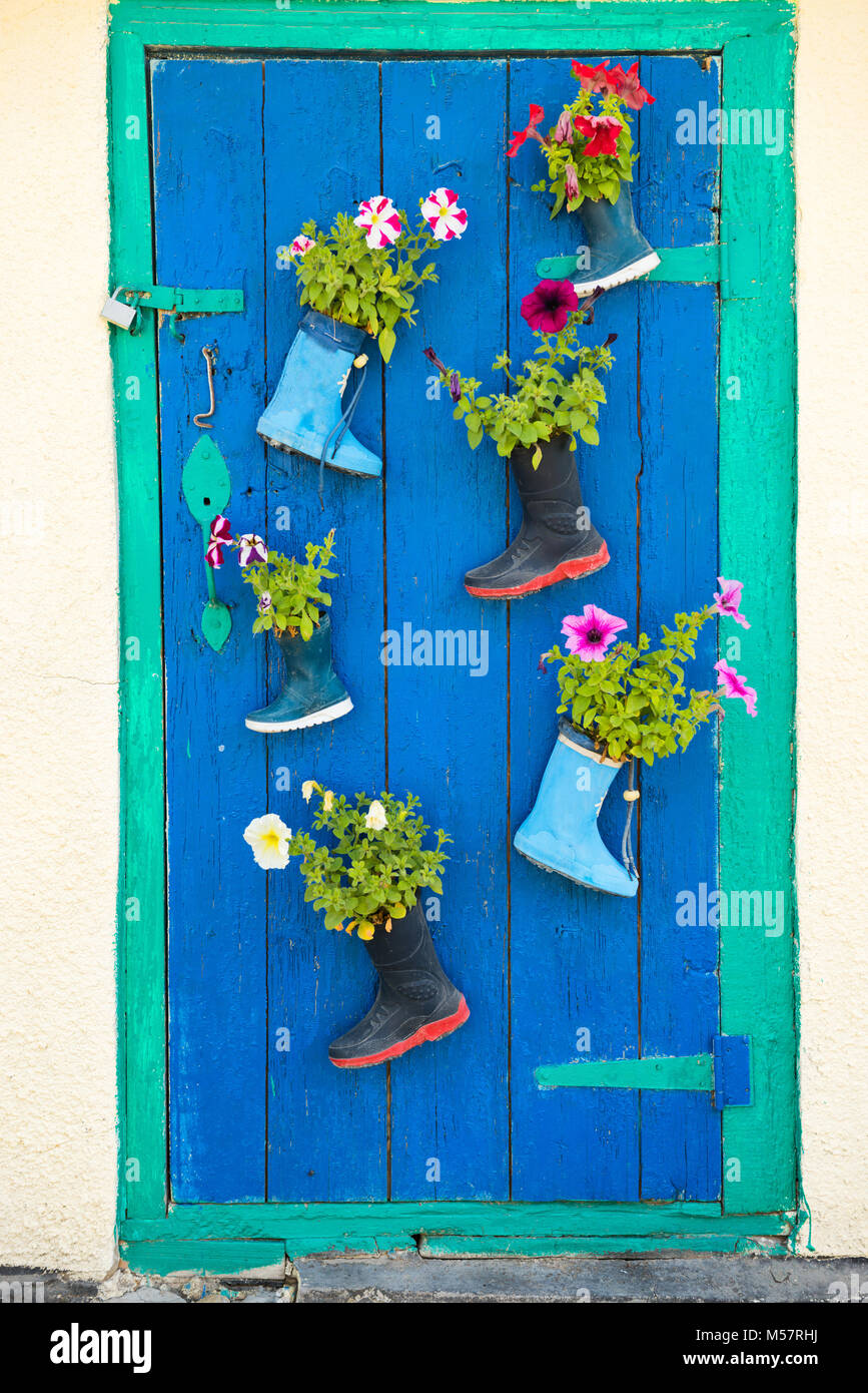 Vieilles bottes en caoutchouc avec des fleurs Banque D'Images