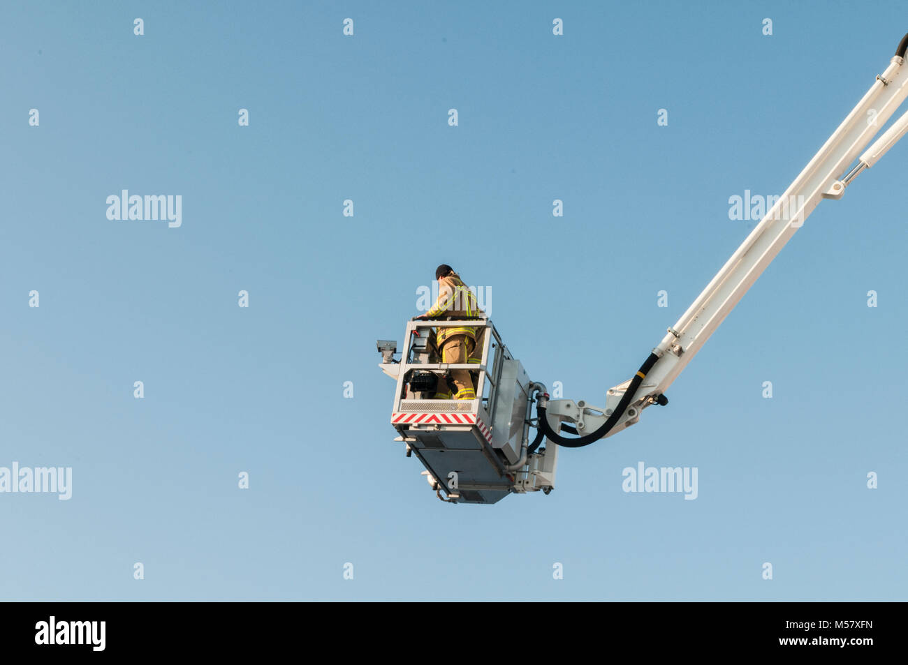 Fireman debout sur un pont d'une brigade de pompiers de bain haut dans le ciel Banque D'Images