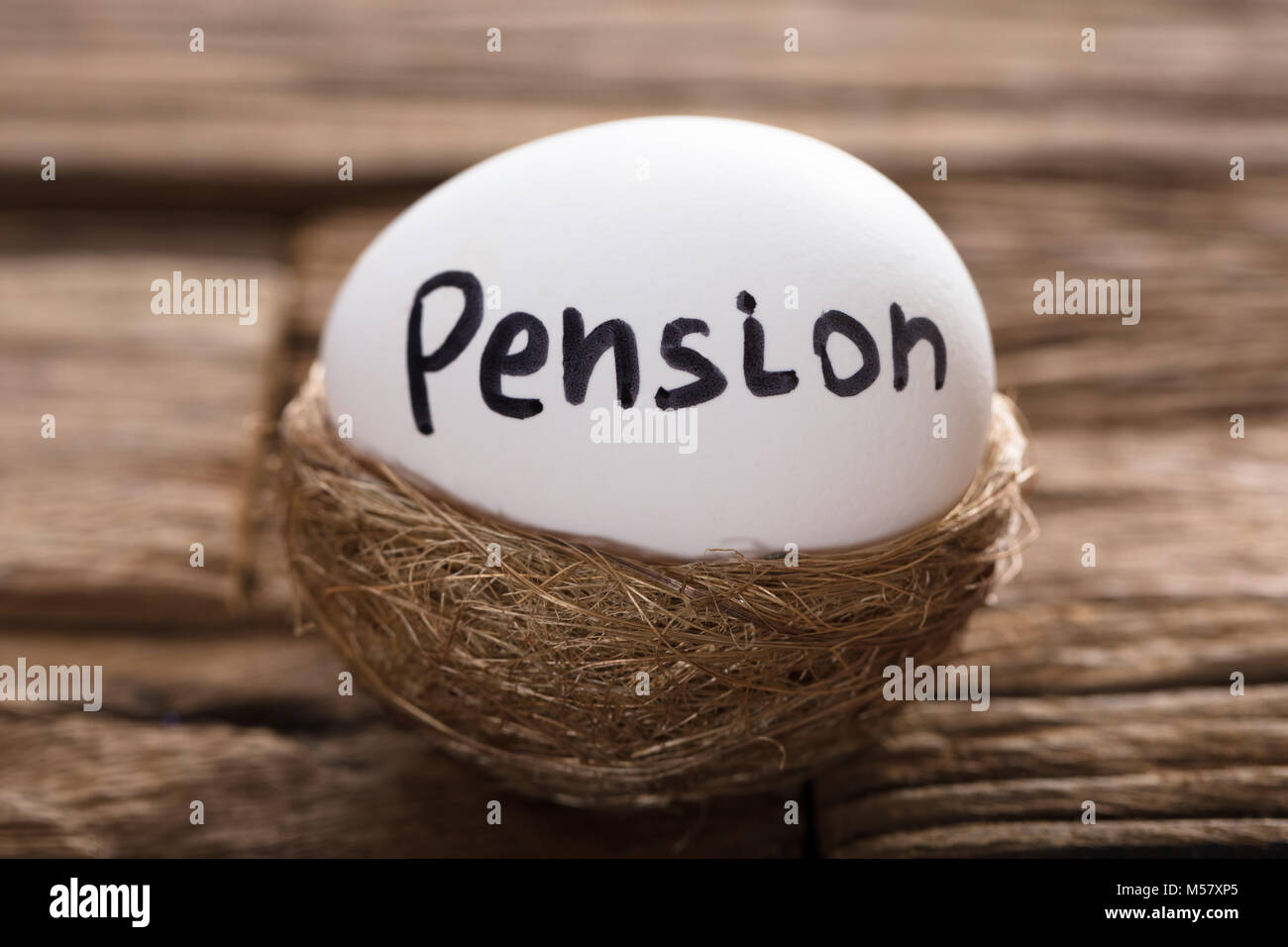 Gros plan du écrit sur pension egg in nest blanc sur bois Banque D'Images