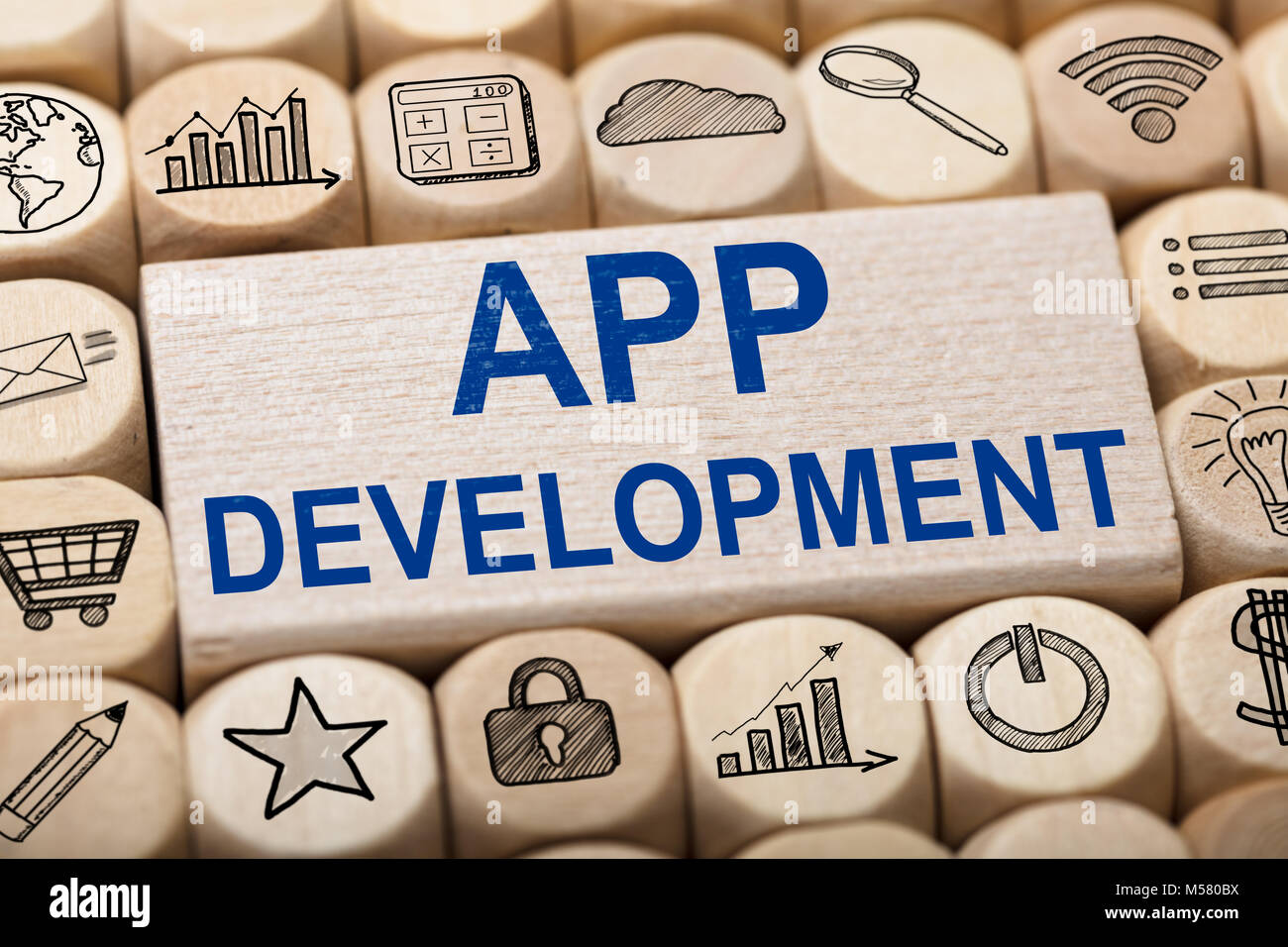 Full Frame shot de texte Développement application sur un bloc en bois entouré par diverses icônes de l'ordinateur Banque D'Images