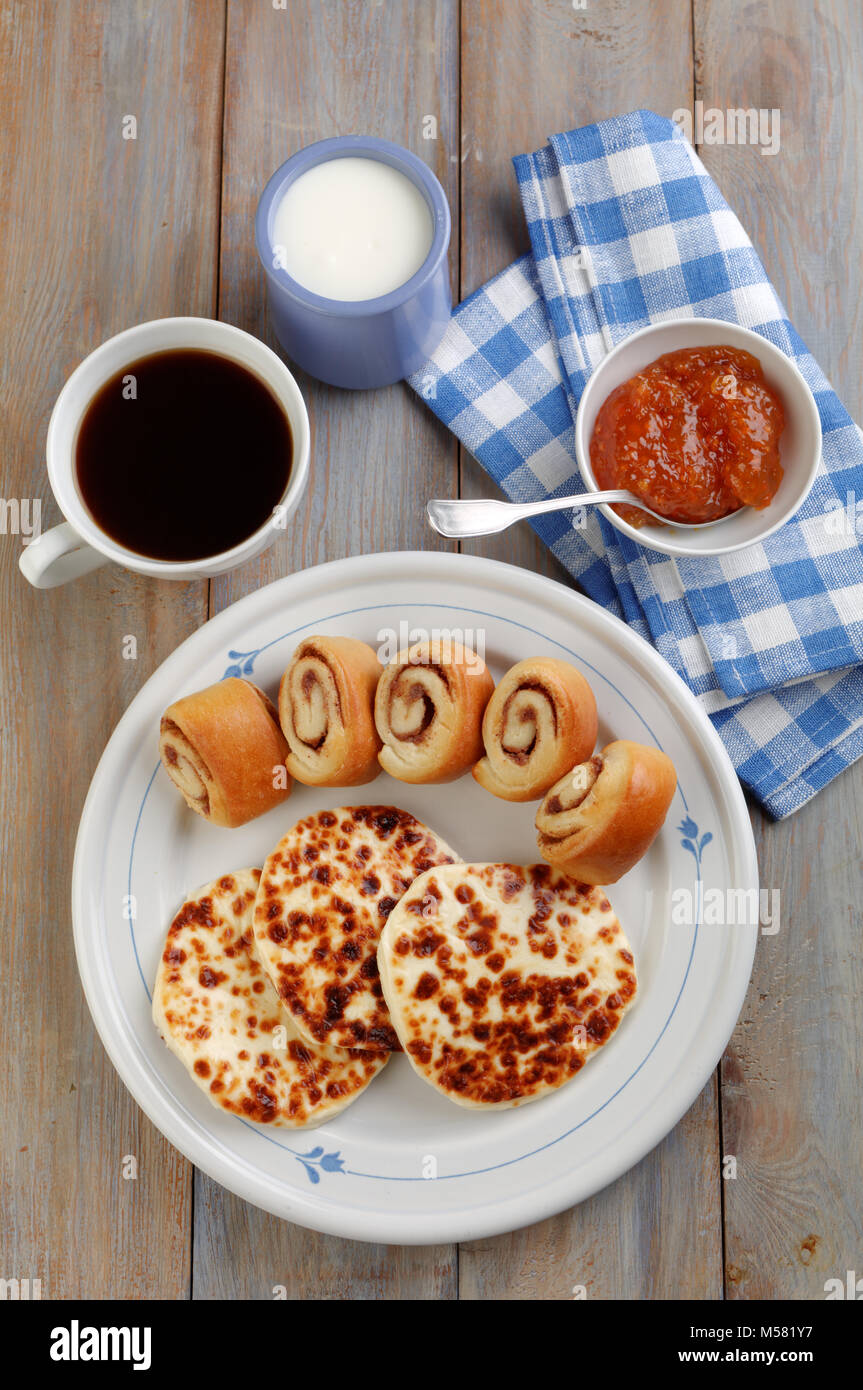 Petit-déjeuner finlandais Leipajuusto avec fromage grinçant, mini brioches à la cannelle, Confiture de mûres, et du café noir Banque D'Images