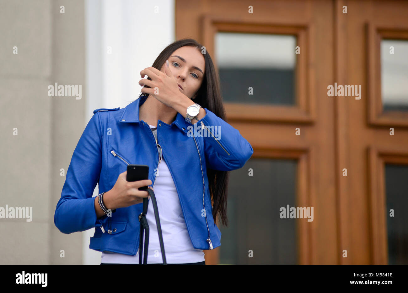 Une jeune fille aux yeux bleus portant une veste en cuir bleu - Kaunas, Lituanie Banque D'Images