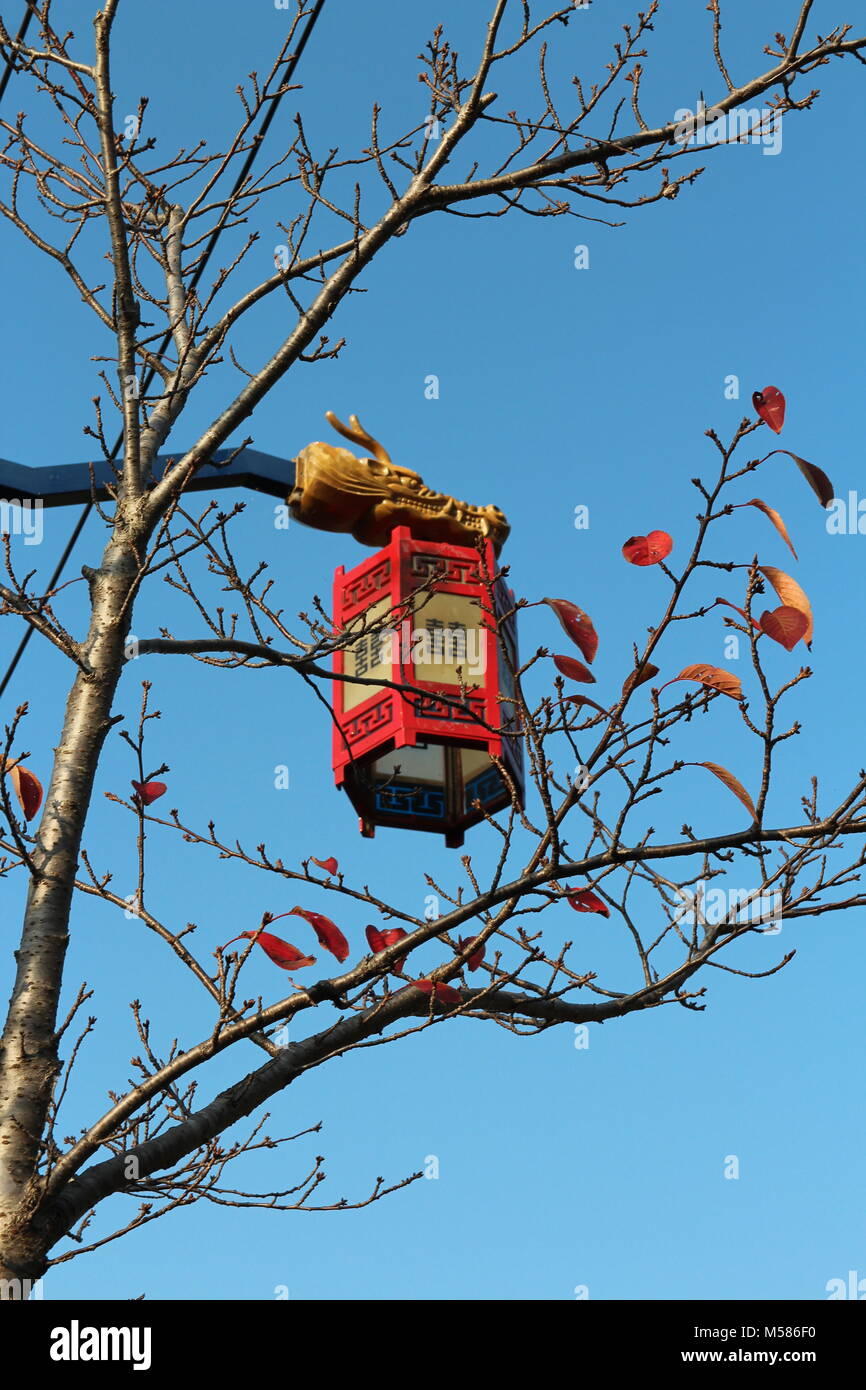 Lampe de rue avec tête de dragon et lanterne rouge avec les mots chinois comme symbole de bonheur double en journée ensoleillée, Busan, Corée du Sud Banque D'Images