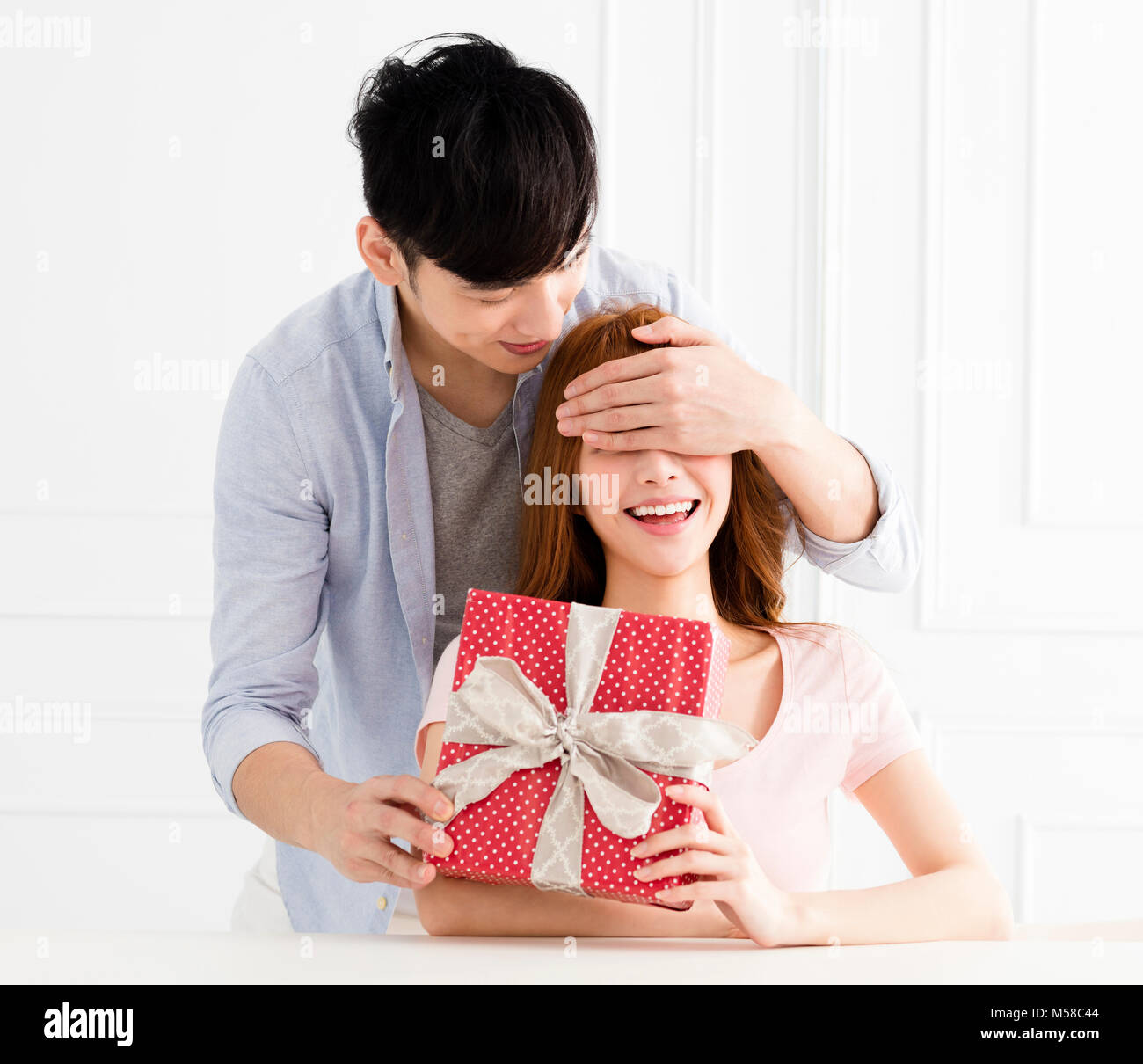 Jeune homme surprises avec sa petite amie à la maison actuelle Banque D'Images