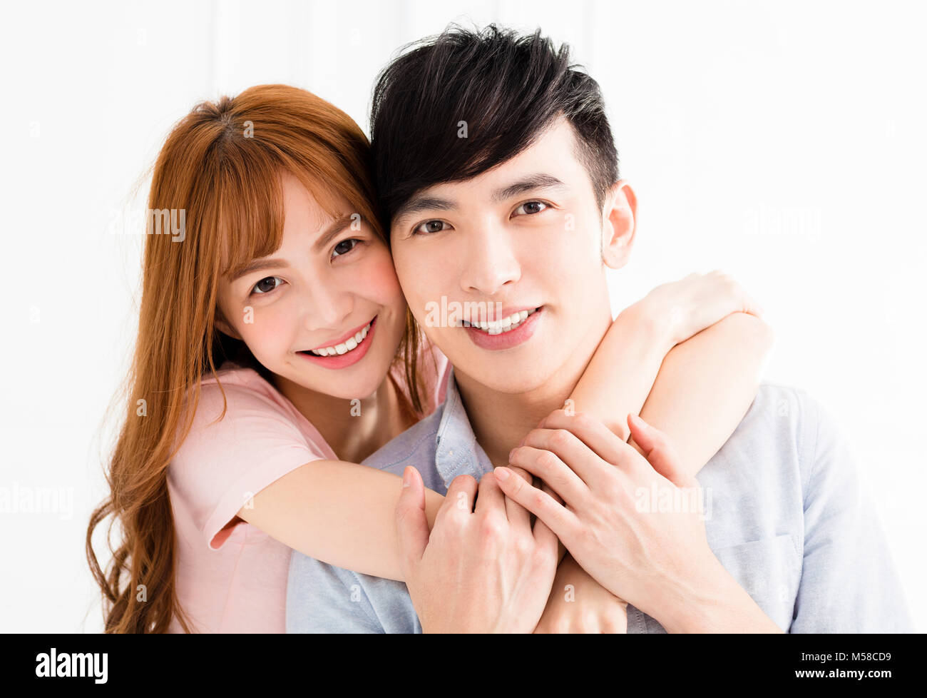 Happy young couple hugging in living room Banque D'Images
