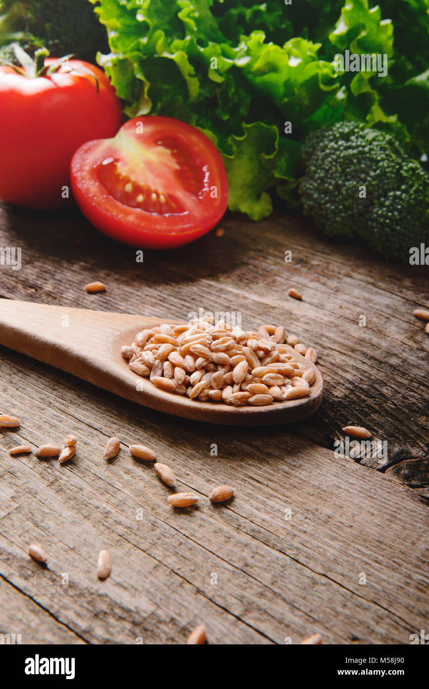 Une alimentation saine avec des graines, des tomates et de la salade sur la table en bois Banque D'Images