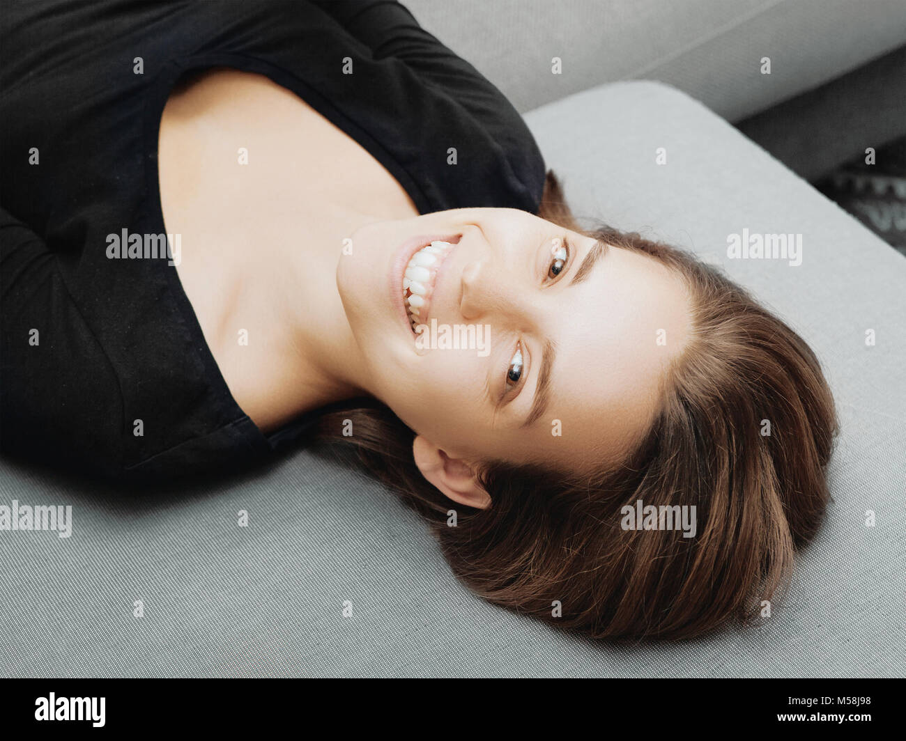 Woman smiling on sofà, heureux face Banque D'Images