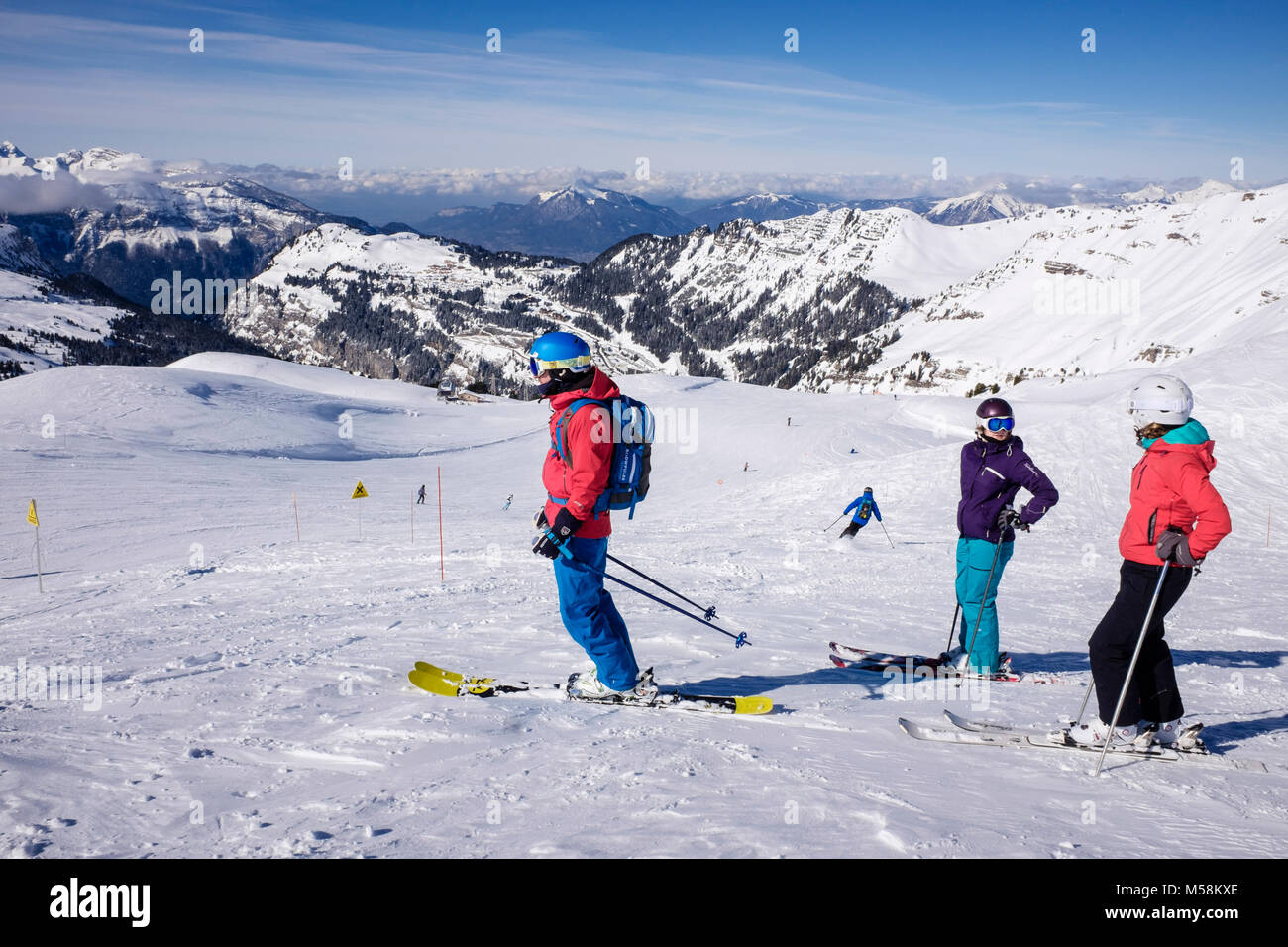 Ski skieurs sur red route de ski dans le domaine skiable du Grand Massif dans les Alpes en hiver la neige au-dessus de Flaine, Haute Savoie, Rhône-Alpes, France, Europe Banque D'Images