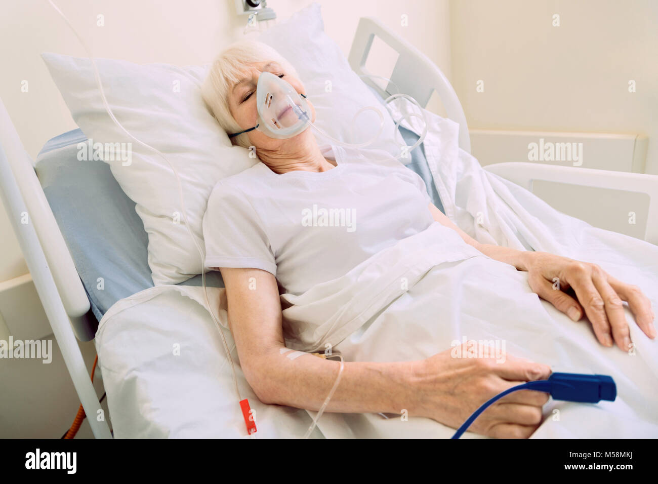 Épuisé woman Lying in Bed avec masque respiratoire Banque D'Images