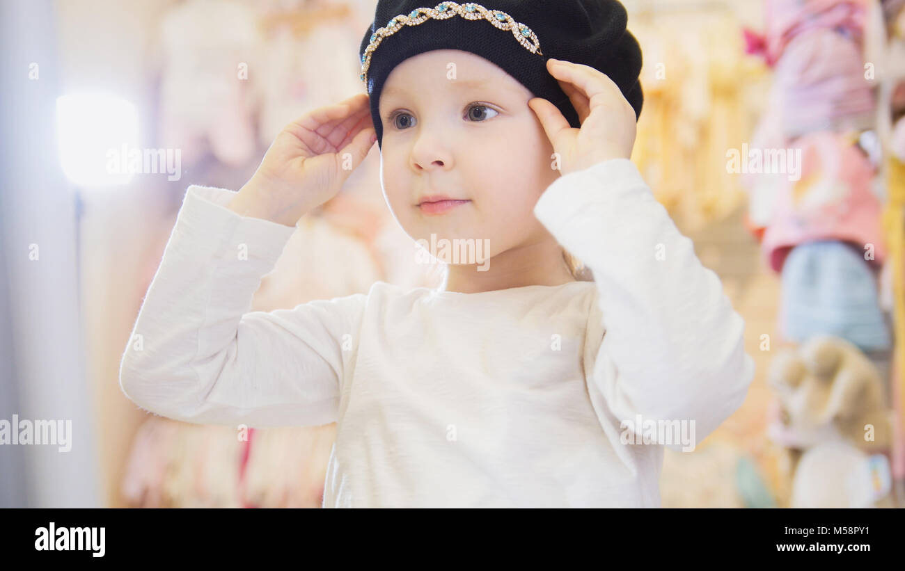 Belle fille essaie sur un béret noir Banque D'Images