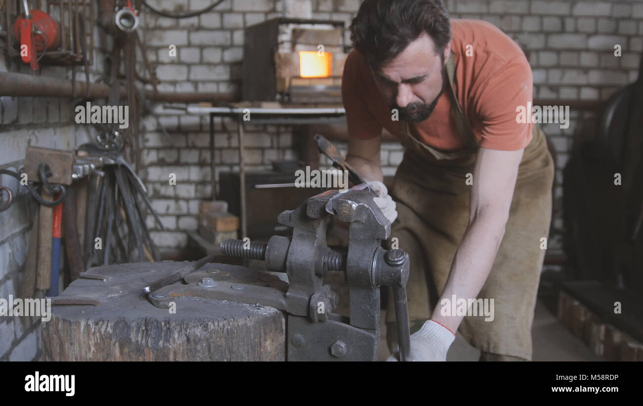 Jeune homme musclé travaille sur un forgeron avec metal Banque D'Images