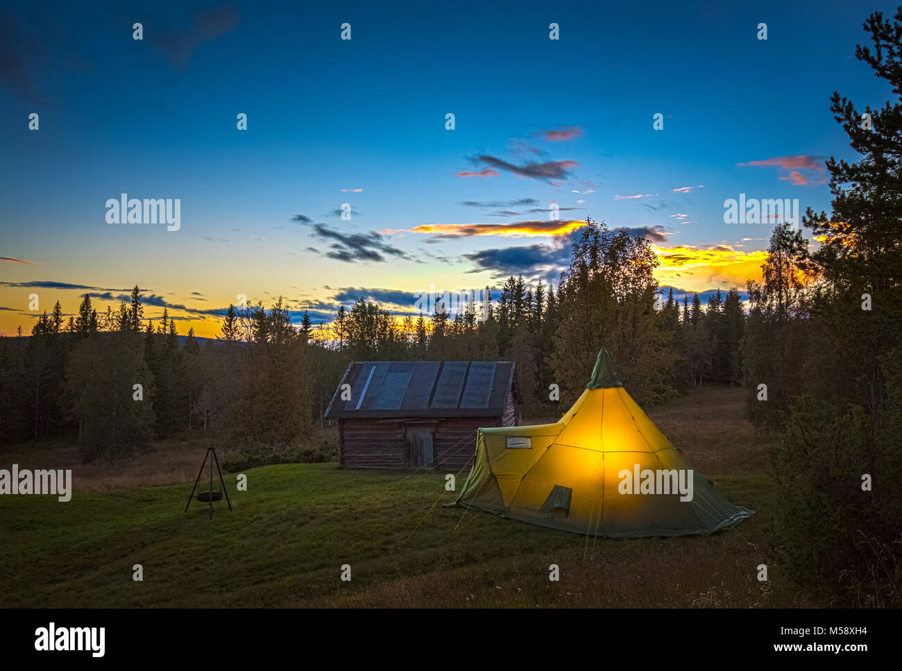 Grande tente, un livre, illuminée de l'intérieur avec flash. La couleur est  frappant contre le ciel bleu et orange au coucher du soleil Photo Stock -  Alamy