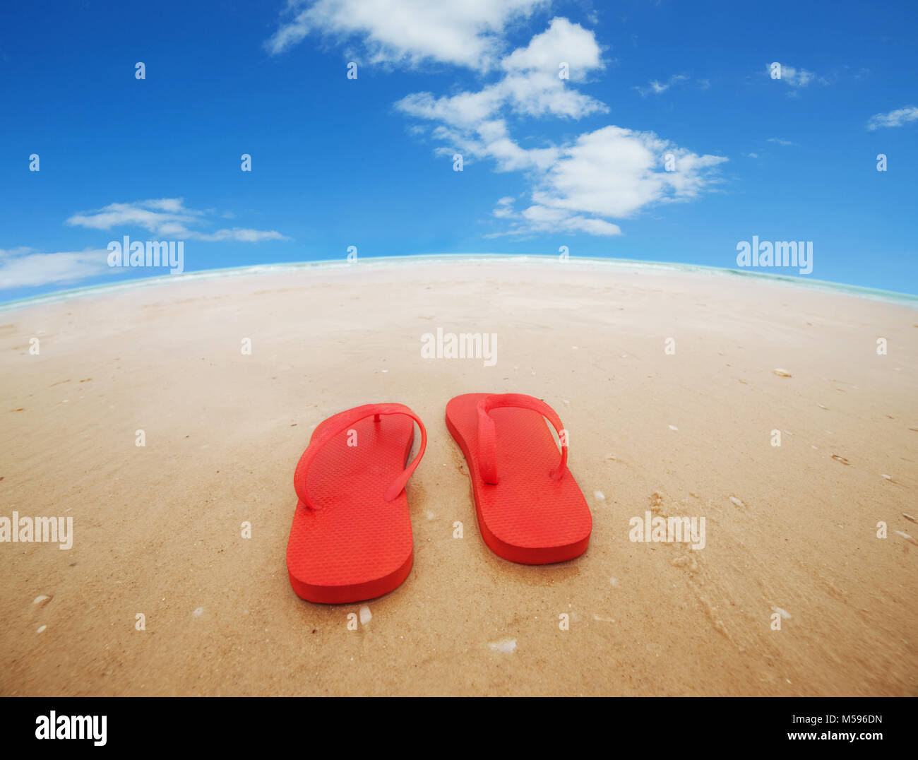 Tongs rouges sur la plage.Concept de vacances estivales.wide angle Banque D'Images