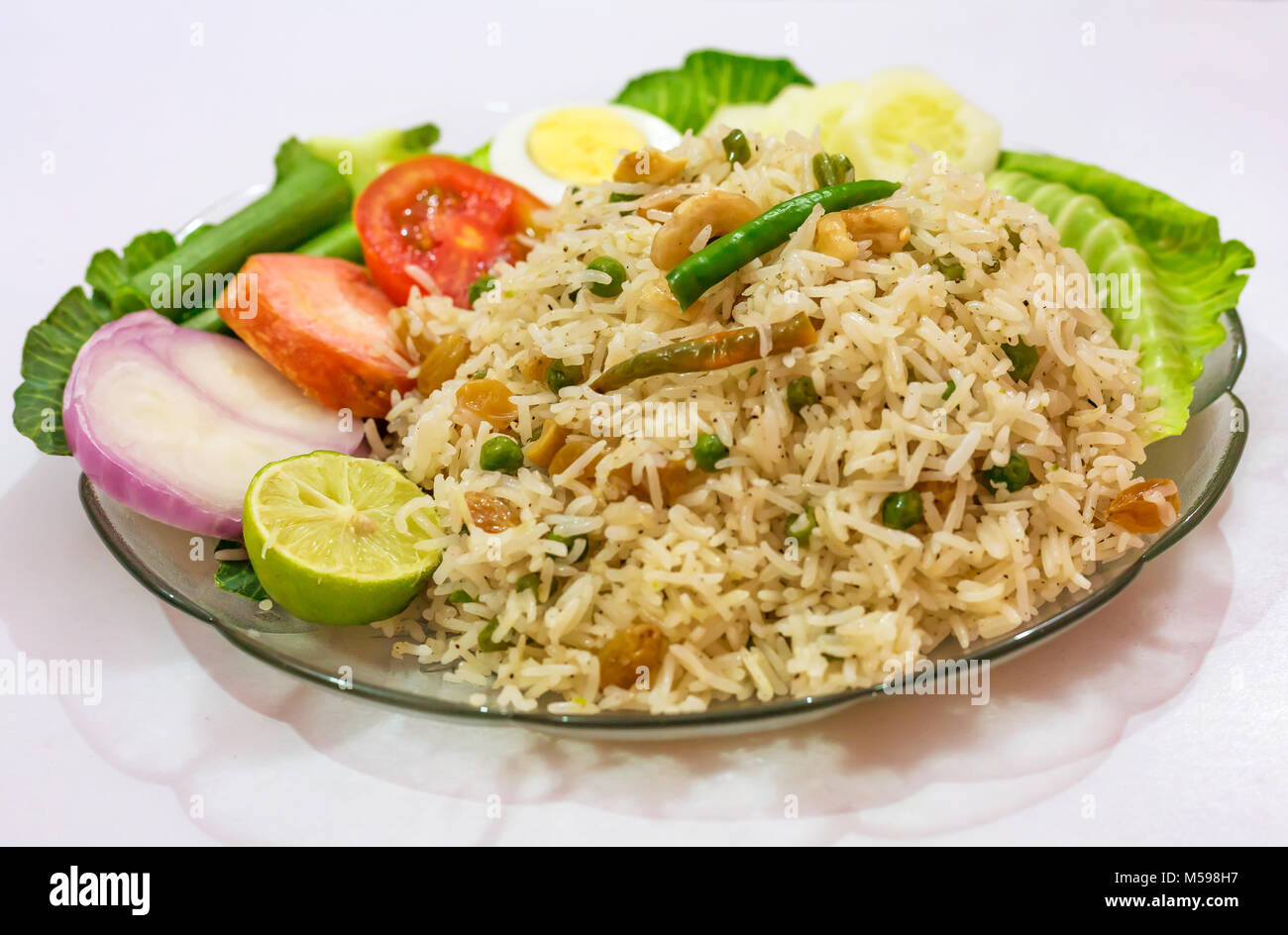 Indiens les repas de riz pulao frit avec des tranches d'oeufs et de légumes verts. Banque D'Images
