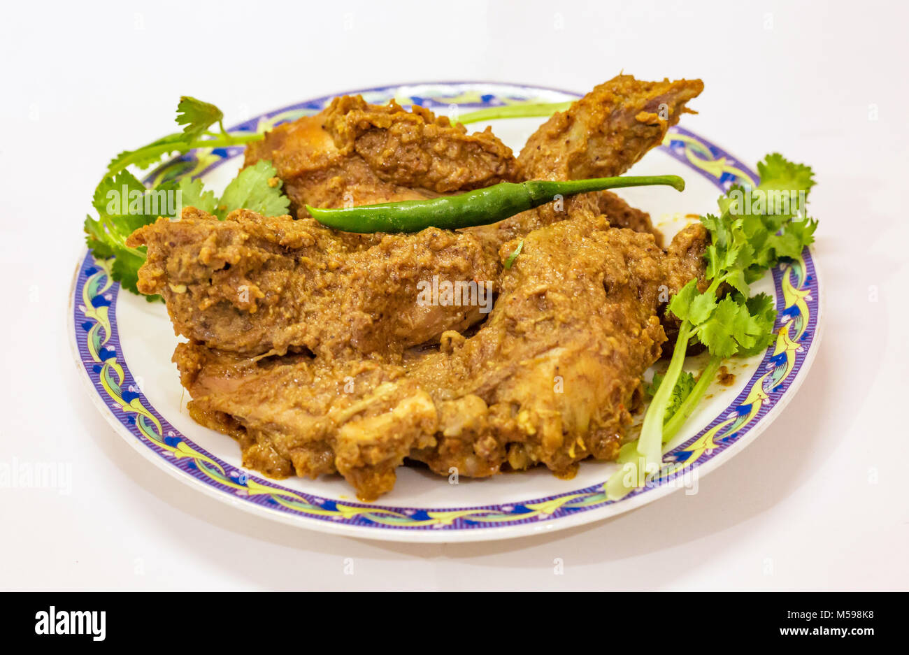 Populaires indiens les repas de sauce épicée au curry de mouton connu sous le nom de mouton kosha avec piment vert et la feuille. Banque D'Images
