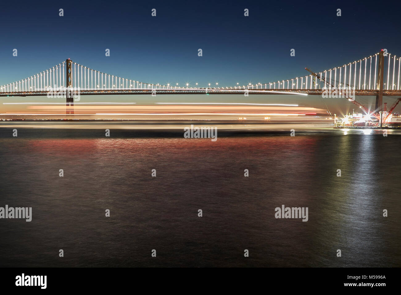 Le San Francisco-Oakland Bay Bridge avec illuminations (La Baie), à l'aube. Banque D'Images