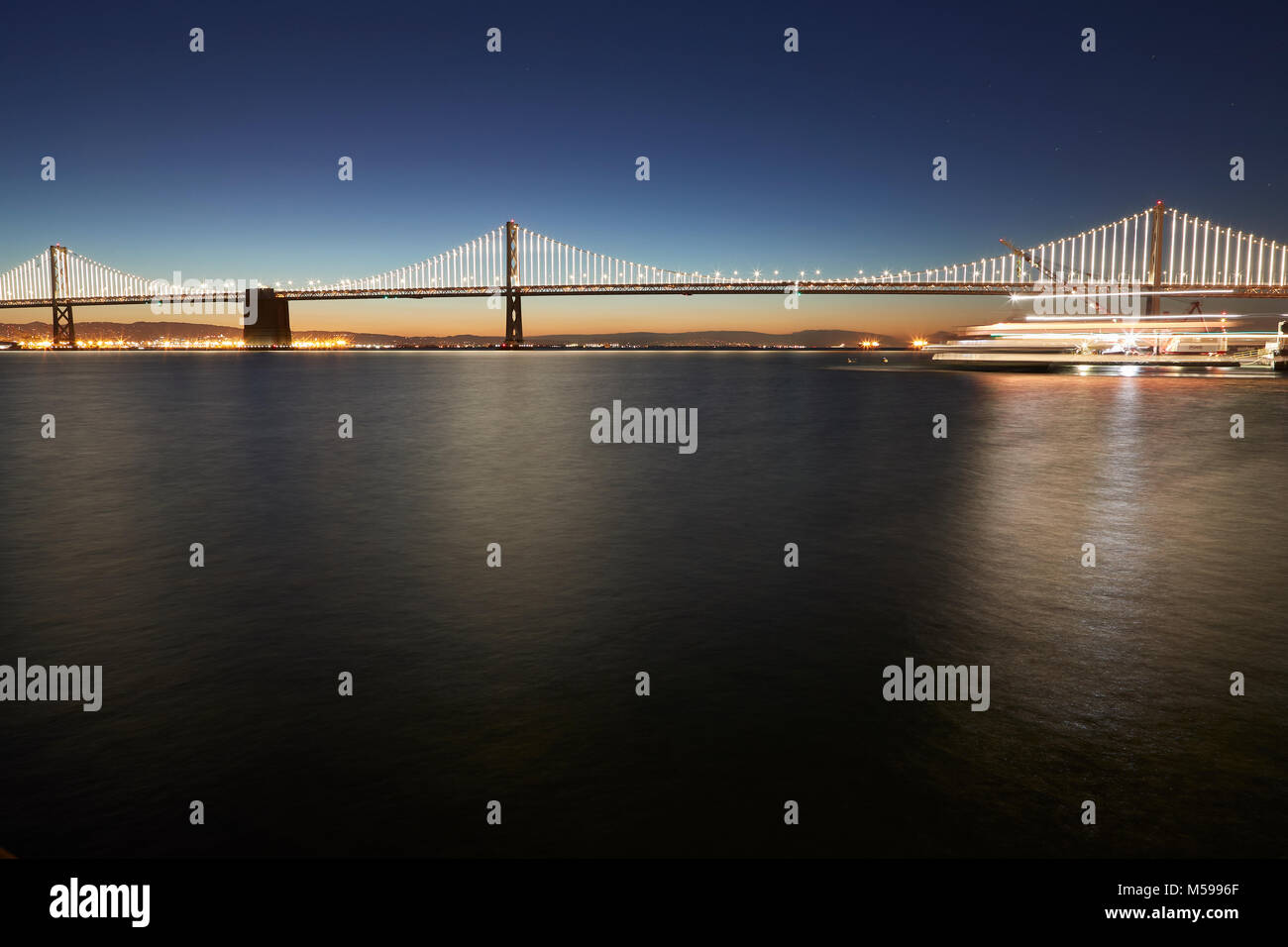 Le San Francisco-Oakland Bay Bridge avec illuminations (La Baie), à l'aube. Banque D'Images