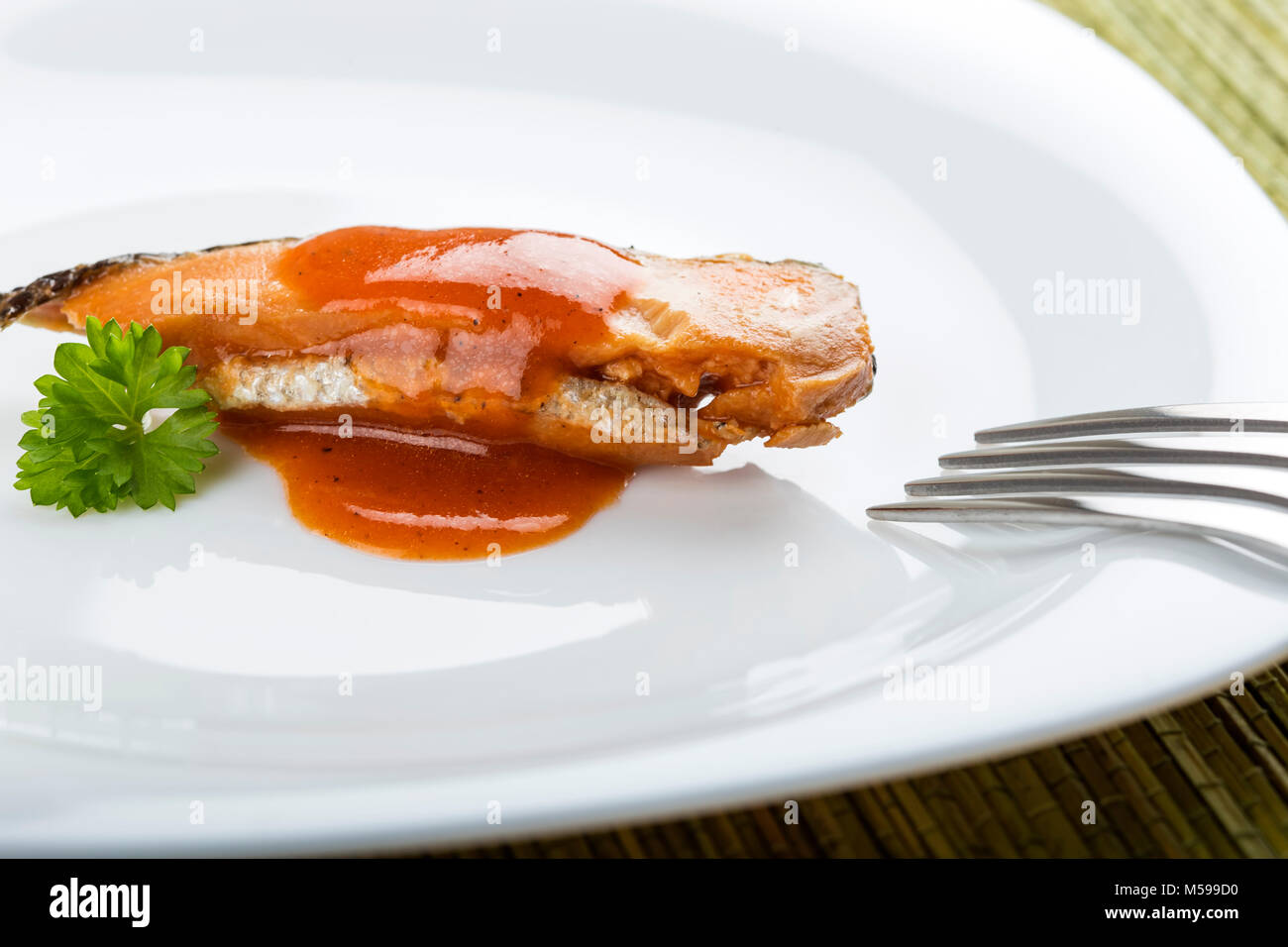 Hareng mariné poisson avec sauce de tomate sur une assiette avec une fourchette Banque D'Images