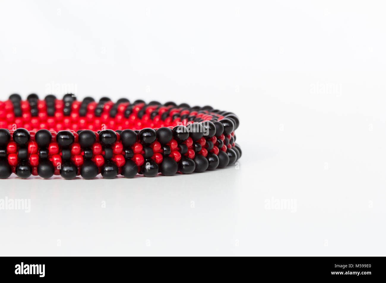 Noir et rouge bracelet en crochet en cordon sur fond blanc Banque D'Images