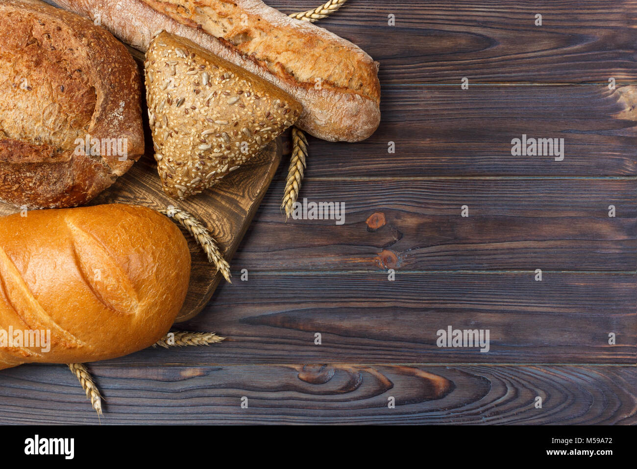 Pain maison cuit au four à pain de blé sur fond de bois. Vue de dessus avec l'exemplaire de l'espace. Banque D'Images