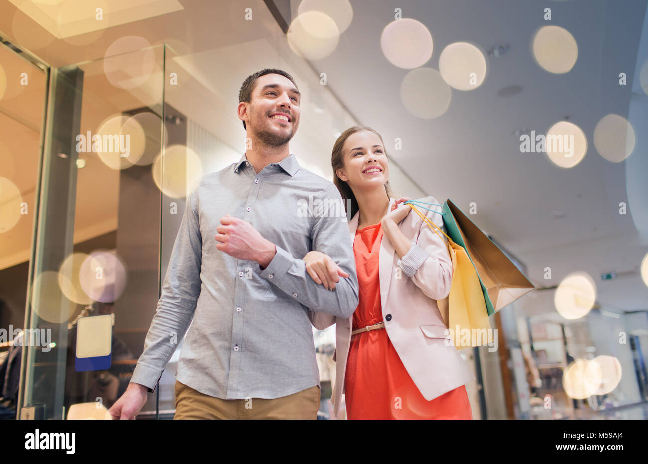 Happy young couple with shopping bags in mall Banque D'Images