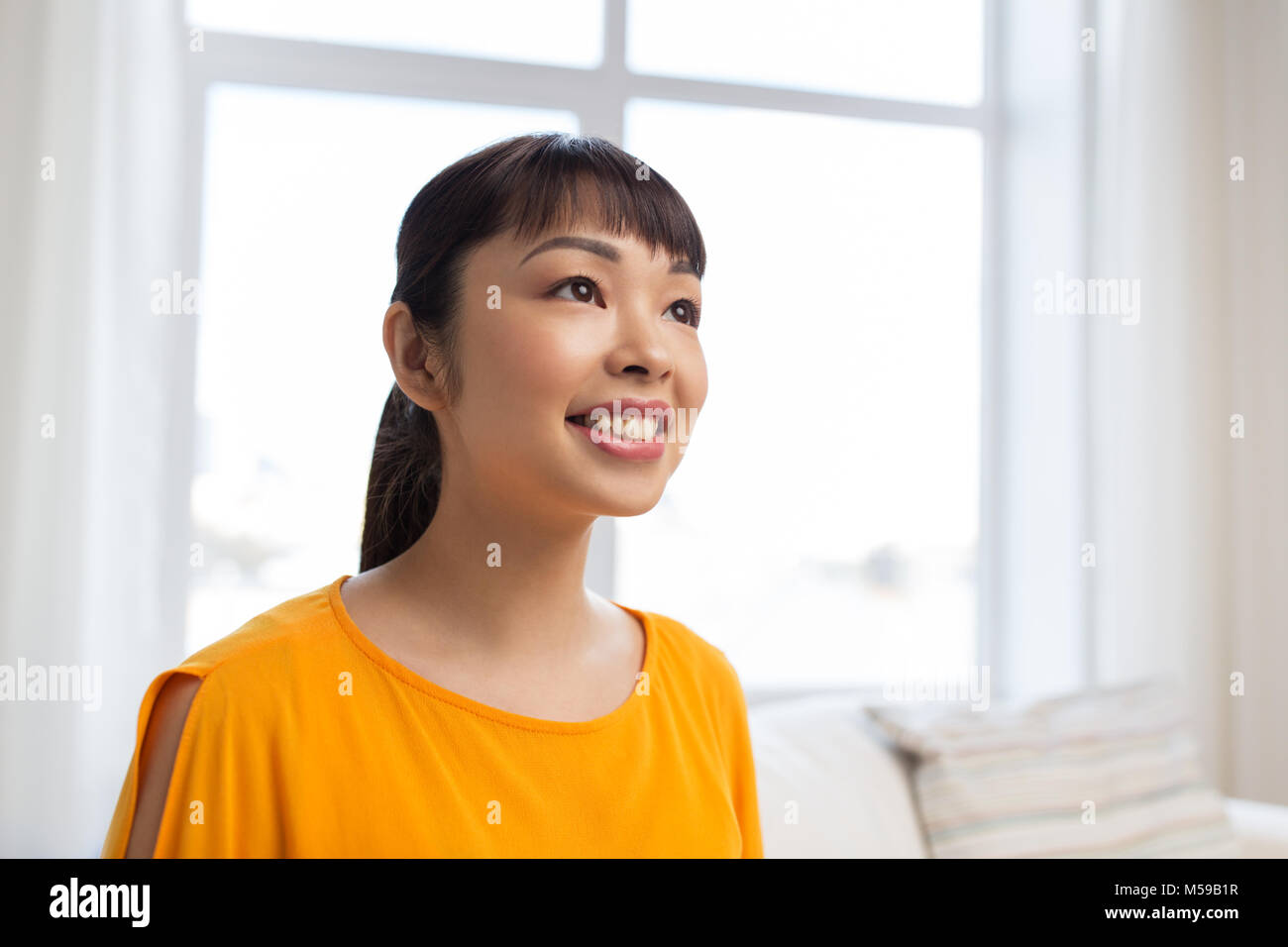 Portrait of smiling young asian woman at home Banque D'Images