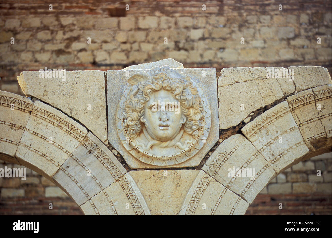 La Libye. Tripoli. Leptis Magna. Ruines Romaines. Sculpture de visage sur des ruines romaines. L'Unesco, site du patrimoine mondial. Site archéologique de Leptis Magna. Banque D'Images