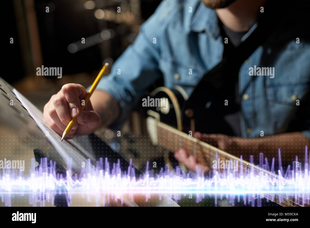 Musicien avec guitare et musique au studio Banque D'Images
