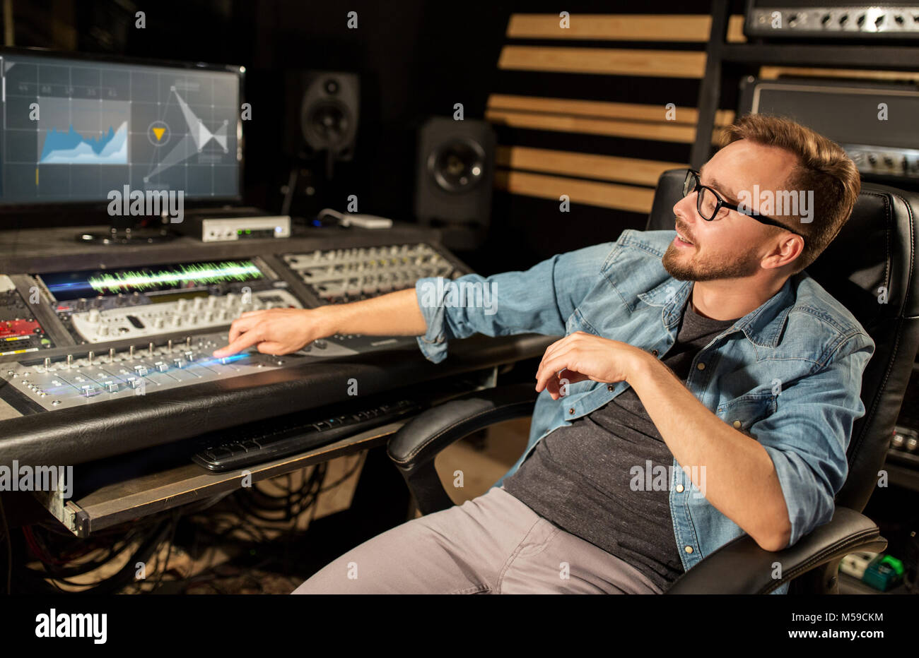 L'homme à une console de mixage en studio d'enregistrement musique Banque D'Images