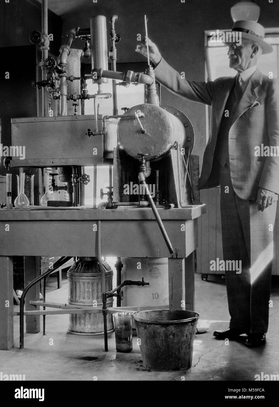 Un homme mûr et son expérience scientifique dans le laboratoire, ca. L'année 1930. Banque D'Images