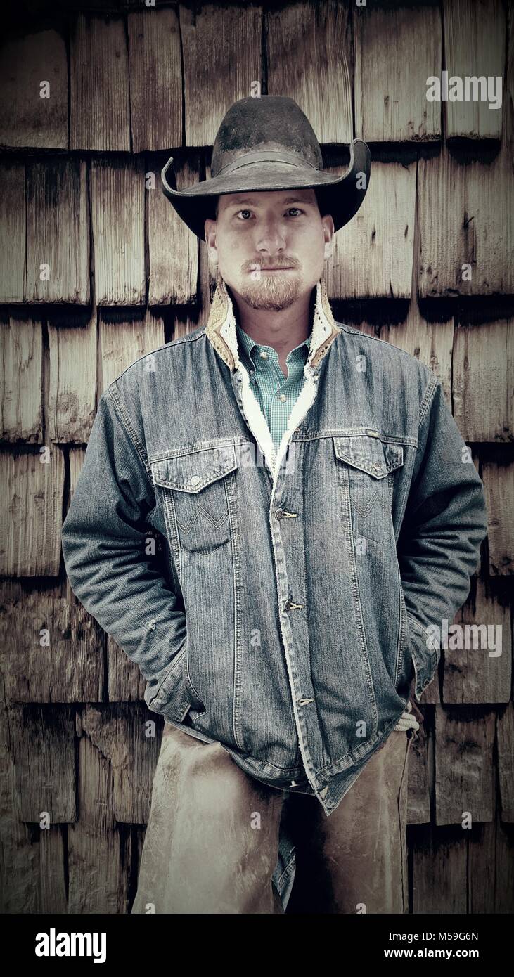 Cowboy millénaire contre hangar en bois avec les mains en veste en jean  Photo Stock - Alamy